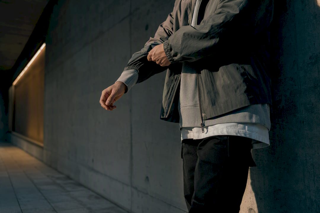 Person trägt eine übergroße Jacke im urbanen Layering-Stil