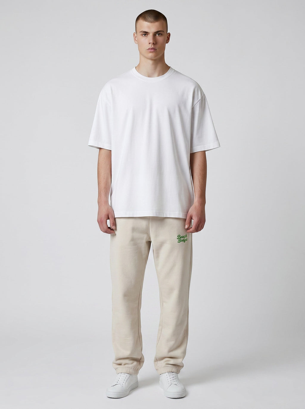 BeachBodyz® oversized beige cotton blend jogging pants with embroidered logo on left hip. Elastic waistband and cuffs.