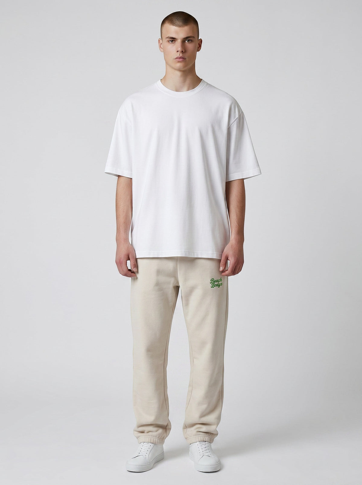 BeachBodyz® oversized beige cotton blend jogging pants with embroidered logo on left hip. Elastic waistband and cuffs.