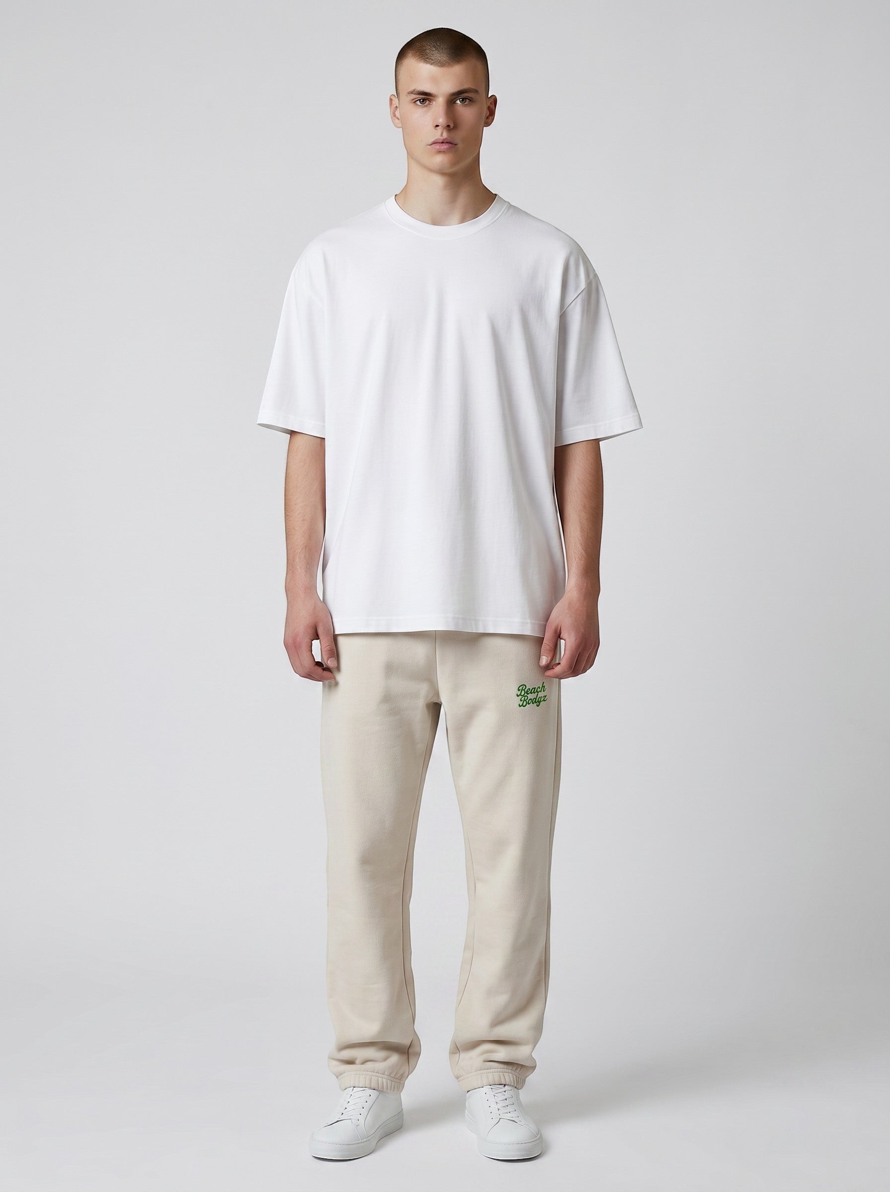 BeachBodyz® oversized beige cotton blend jogging pants with embroidered logo on left hip. Elastic waistband and cuffs.