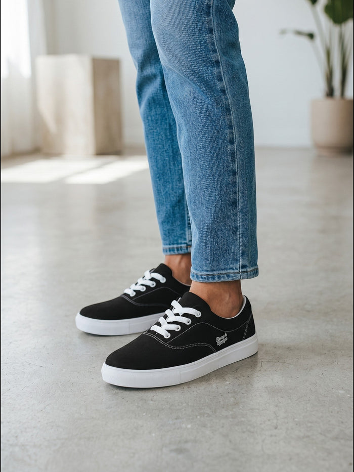 BeachBodyz® black canvas low-top sneakers with white laces and white soles. Casual, stylish footwear.