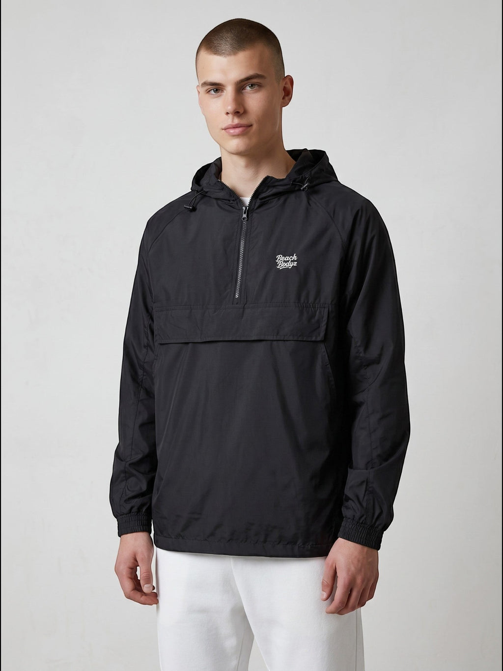 BeachBodyz® black lightweight windbreaker jacket with hood and quarter zip, featuring a chest logo and kangaroo pocket.
