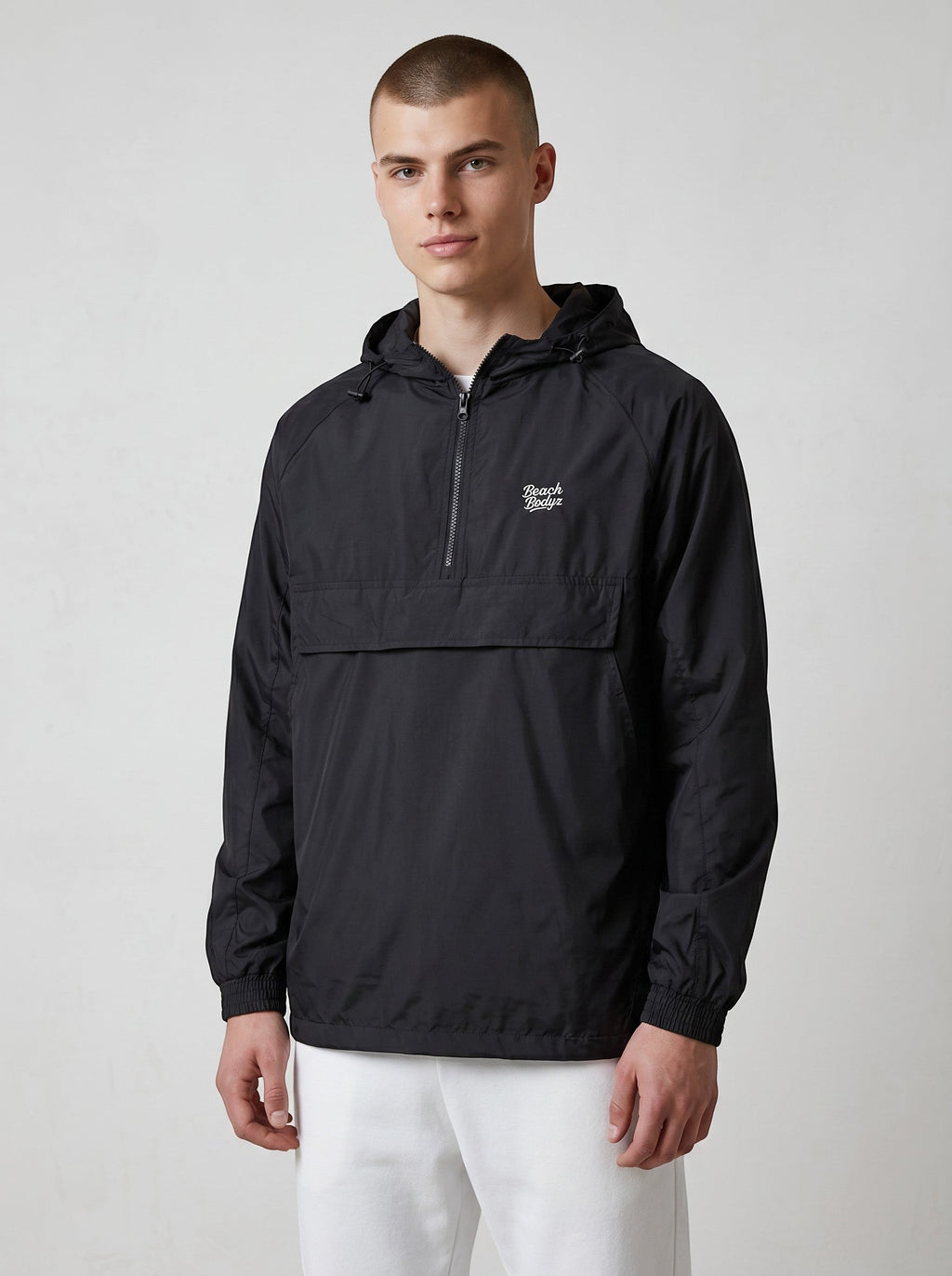 BeachBodyz® black lightweight windbreaker jacket with hood and quarter zip, featuring a chest logo and kangaroo pocket.