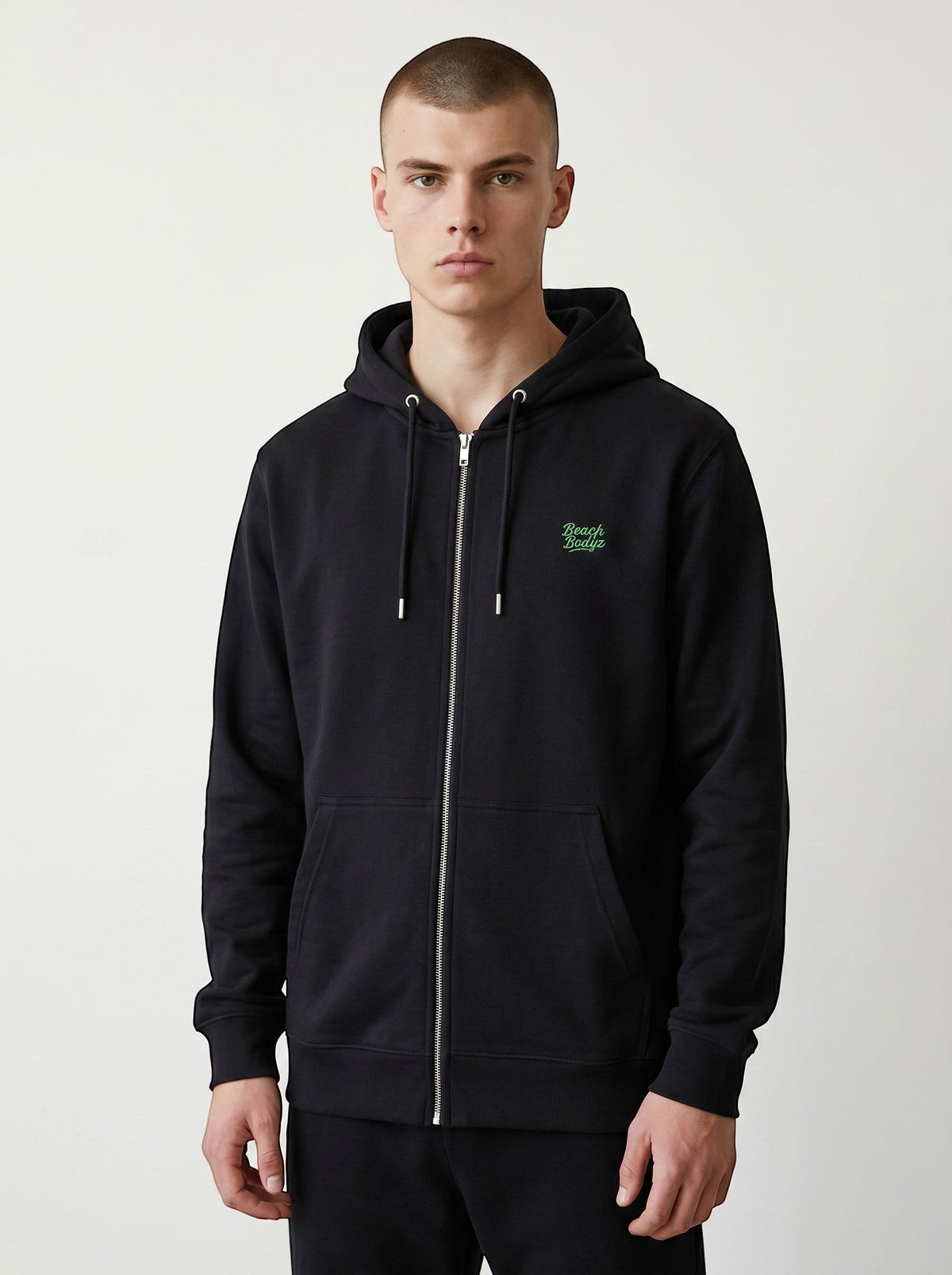 BeachBodyz® black zip-up hoodie with green embroidered logo on chest, made from soft organic cotton.