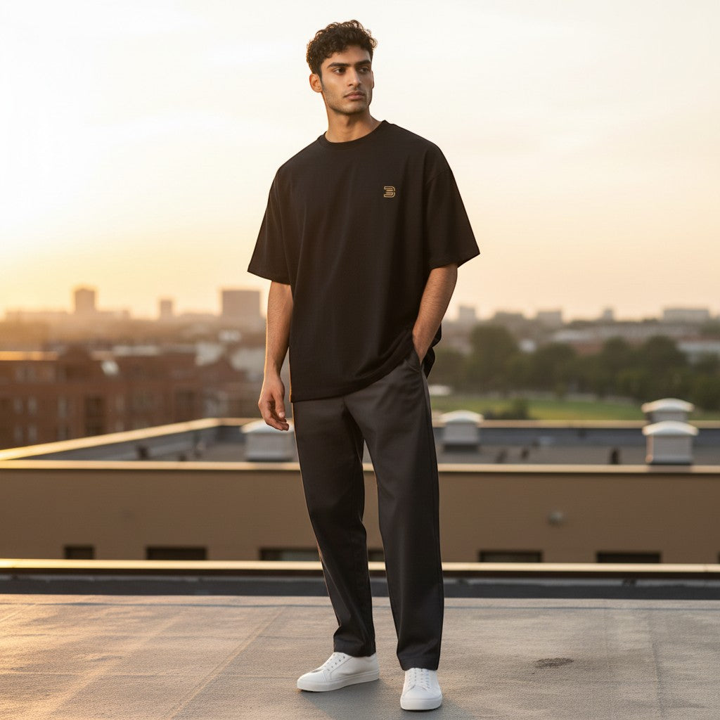 BeachBodyz® black oversized cotton t-shirt with small gold logo on chest. Casual streetwear style.