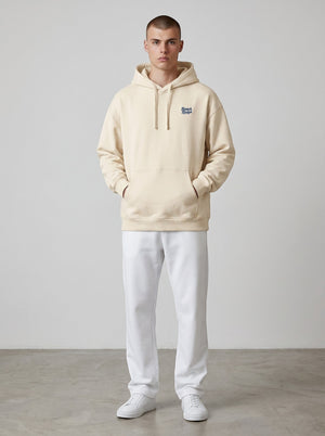 BeachBodyz® cream oversized hoodie made from organic cotton with a blue embroidered logo on the chest and a front pocket.