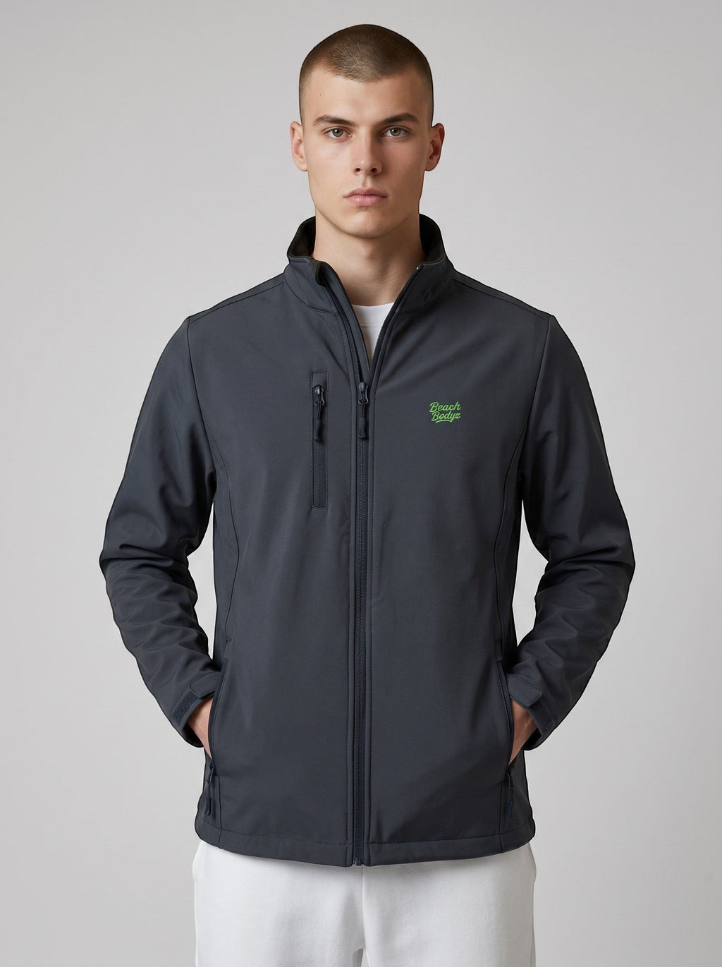 BeachBodyz® dark grey softshell jacket with green logo, zip pockets, and stand-up collar. Water and wind-resistant for streetwear.