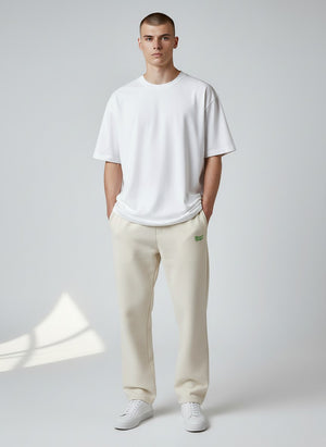 BeachBodyz® light beige cotton-polyester blend jogging pants with green embroidered logo. Comfortable streetwear for men and women.