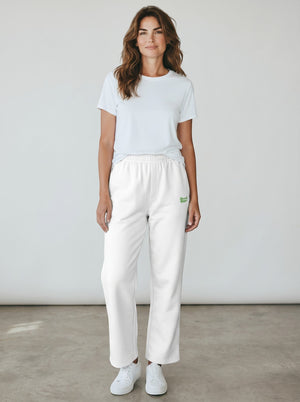 BeachBodyz® white cotton-polyester blend jogging pants with green embroidered logo on left thigh. Elastic waistband, side pockets, and cuffed ankles.