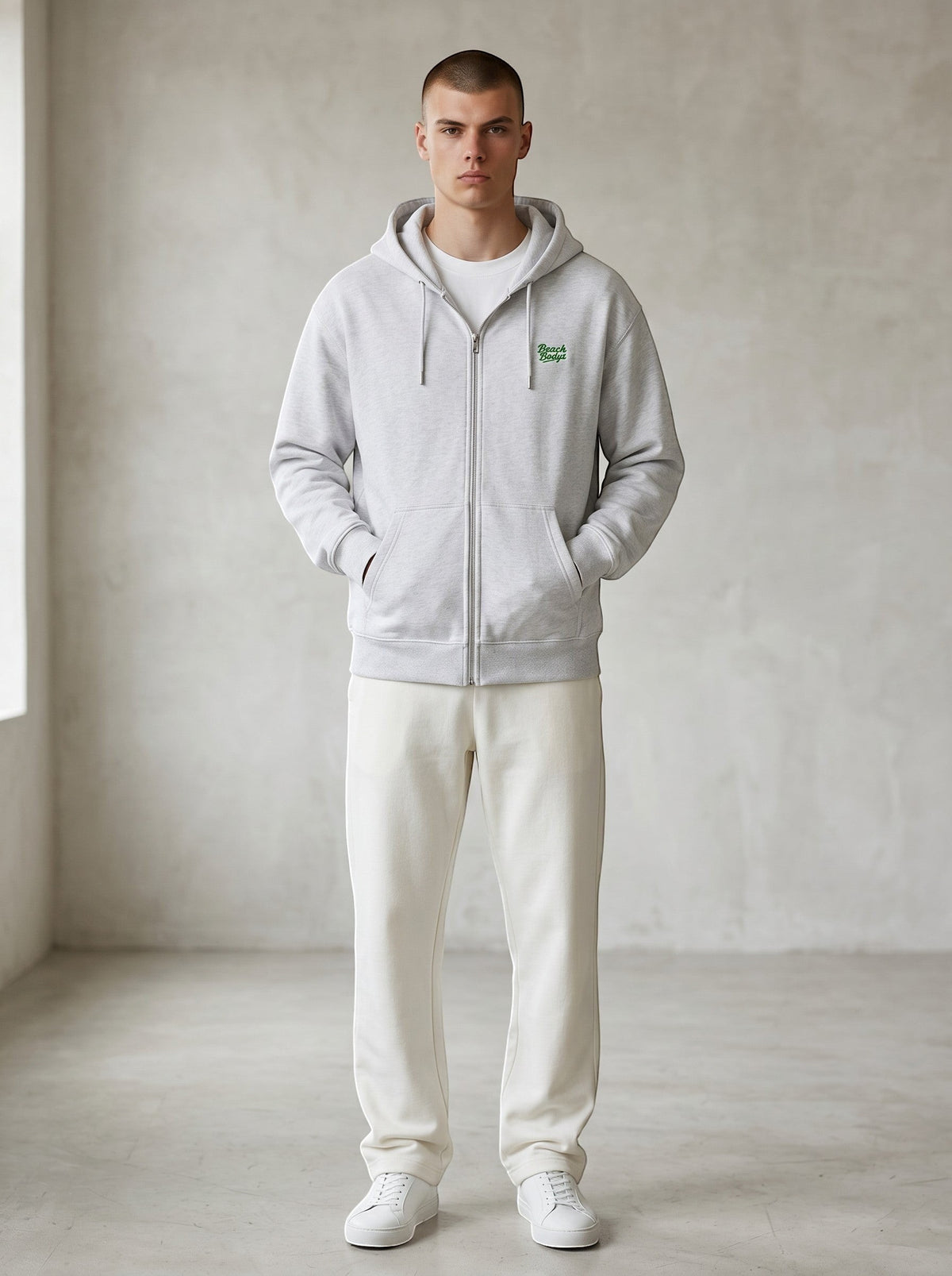 BeachBodyz® white zip-up hoodie with green embroidered logo on chest, made from organic cotton blend.