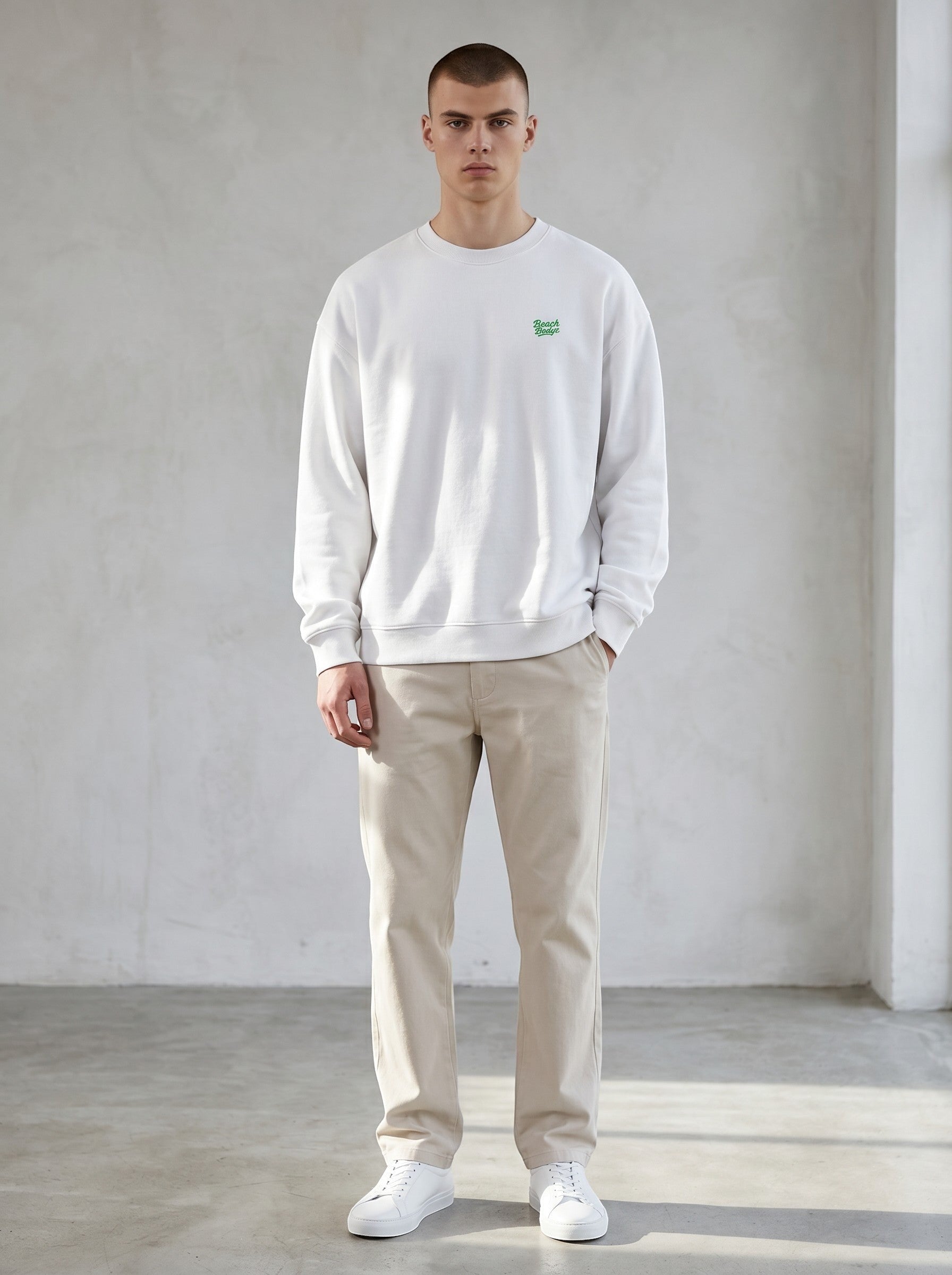 BeachBodyz® white oversized sweatshirt made from organic cotton with a small green embroidered logo on the chest.